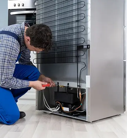 Técnico consertando geladeira